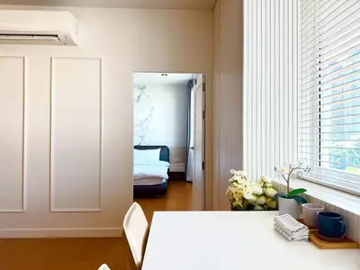 a white room with a table and a bedroom at The Prestige Living Bangkok at Sathorn-Chan in Bangkok