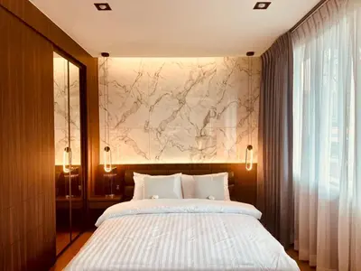 a bedroom with a bed and a marble wall at The Prestige Living Bangkok at Sathorn-Chan in Bangkok