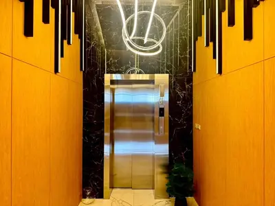 an elevator in a hallway with a chandelier at The Prestige Living Bangkok at Sathorn-Chan in Bangkok