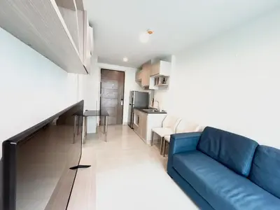 a living room with a blue couch and a kitchen at Bangkok apartment in Bangkok