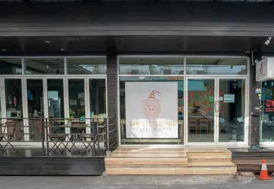 a store front with a sign in the window at The Little Pig Sukhumvit in Bangkok
