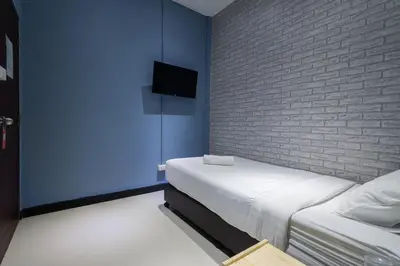 a bedroom with a bed and a brick wall at The Little Pig Sukhumvit in Bangkok