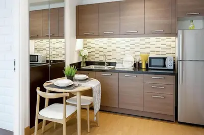 a kitchen with a small table and a refrigerator at New Renovated 2 Beds Amazing Balcony View Nana BTS in Bangkok