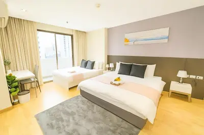 a hotel room with a large bed and a bedroom at Cozy Urban Retreat in Sukhumvit Steps to BTS Nana in Bangkok
