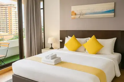 a bedroom with a large bed with yellow pillows at The Wooden Nest Warm Stay at Sukhumvit 8 in Bangkok