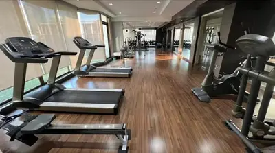 a gym with several treadmills and elliptical machines at The Wooden Nest Warm Stay at Sukhumvit 8 in Bangkok
