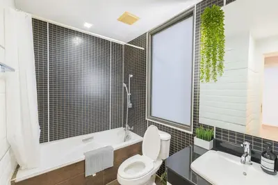 a bathroom with a toilet and a tub and a sink at The Wooden Nest Warm Stay at Sukhumvit 8 in Bangkok