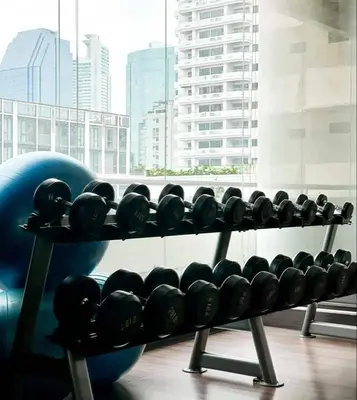 a rack of dumbbells in front of a window at The Wooden Nest Warm Stay at Sukhumvit 8 in Bangkok