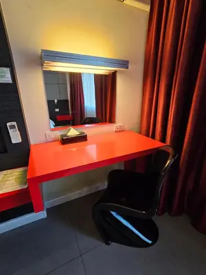 a red desk with a chair and a mirror at The Park Residence in Bangkok