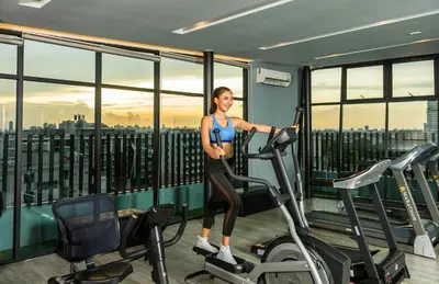 a woman on a treadmill in a gym at De Botan Srinakarin Hotel & Residence in Bangkok