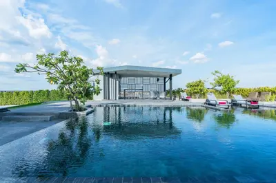 a swimming pool in front of a house at De Botan Srinakarin Hotel & Residence in Bangkok