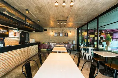 a restaurant with tables and chairs and a brick wall at De Botan Srinakarin Hotel & Residence in Bangkok
