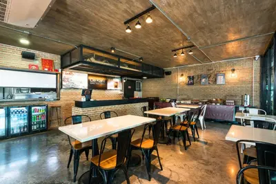a restaurant with tables and chairs in a room at De Botan Srinakarin Hotel & Residence in Bangkok