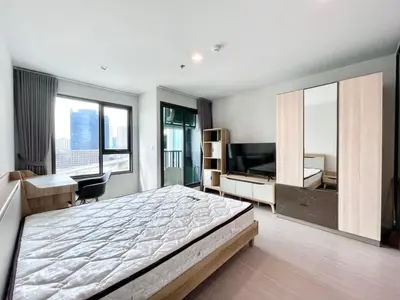 a bedroom with a bed and a desk and a television at 1 bedroom Life Ladprao in Bangkok
