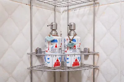a metal shelf with four bottles of soap on it at Restiny Hostel in Bangkok