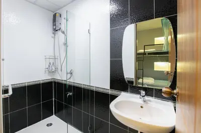 a bathroom with a sink and a mirror at Restiny Hostel in Bangkok