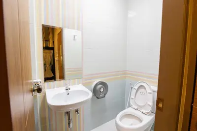 a bathroom with a toilet and a sink at Restiny Hostel in Bangkok