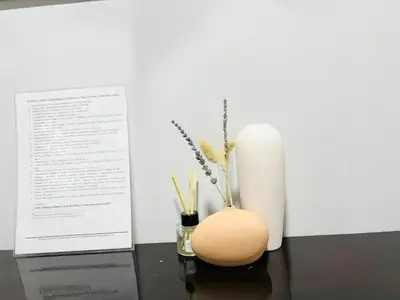 a vase with flowers and a candle on a table at Sukhumvit soi 4 Apartment Center of BKK in Bangkok