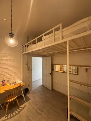 a room with a bunk bed and a desk and a table at TWH Hostel Bangkok in Bangkok