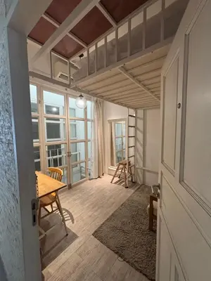 a room with a table and chairs and a window at TWH Hostel Bangkok in Bangkok