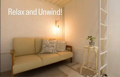a couch in a room with a sign that reads relax and unified at TWH Hostel Bangkok in Bangkok