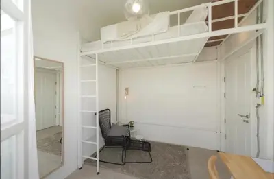 a room with two bunk beds and a chair at TWH Hostel Bangkok in Bangkok
