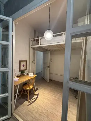 a room with a desk and a loft bed at TWH Hostel Bangkok in Bangkok