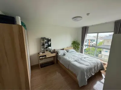 a bedroom with a bed and a desk and a window at 1 bd at s&s sukhumbit in Amphoe Phra Khanong