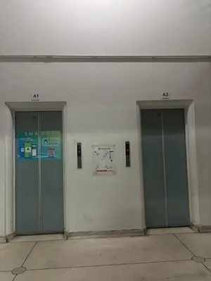 two elevators in a building with two doors at Ally home 14 06 in Thung Si Kan