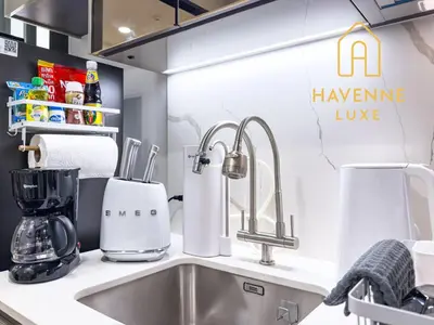 a kitchen counter with a sink and a kitchen appliance at New City Condo in Central Bangkok in Pratunam