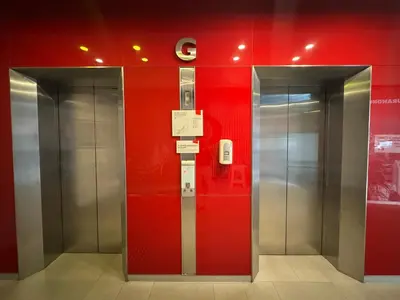 an elevator in a building with a red wall at Easy Planet Bangkok Surawong in Bangkok