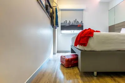 a bedroom with a bed and a suitcase on the floor at Easy Planet Bangkok Surawong in Bangkok