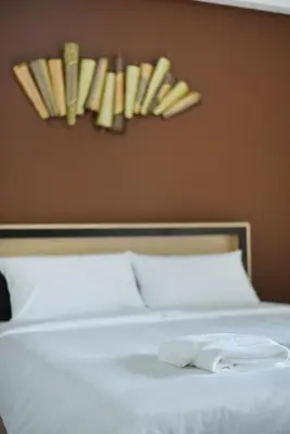 a bed with a white towel on top of it at B32 Apartment in Bangna