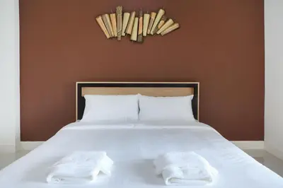 a bed with two white towels on top of it at B32 Apartment in Bangna