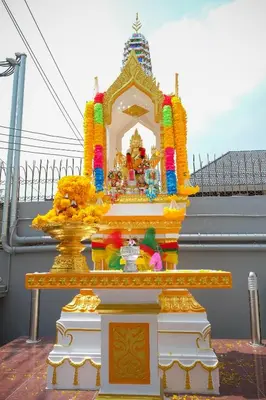 a temple with a idol in front of a building at B32 Apartment in Bangna