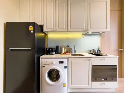 a kitchen with a refrigerator and a washing machine at Near BTS l Large 50 sqm l Luxury facilities l Rooftop Pool in Bangkok