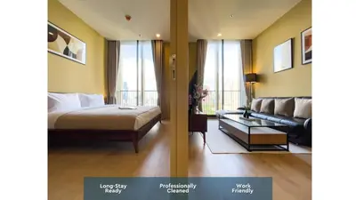 a bedroom with a bed and a living room with a couch at Near BTS l Large 50 sqm l Luxury facilities l Rooftop Pool in Bangkok