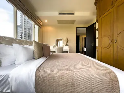 a bedroom with a large bed with a large window at 300m BTS l Large 110 sqm l Pool and Sauna in Bangkok
