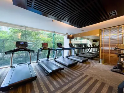 a gym with a row of treadmills in a room at 300m BTS l Large 110 sqm l Pool and Sauna in Bangkok