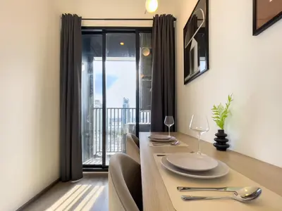 a dining room with a table and a large window at Near BTS l Central Sukhumvit l Pool and Sauna in Bangkok