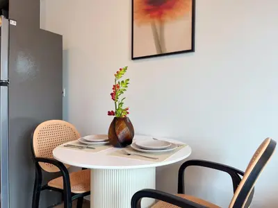 a small white table with a vase on it at 600 m to BTS l City View l Rooftop Pool in Bangkok