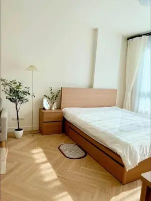 a bedroom with a large bed with white sheets at Minimal Condo At Ramkhamhaeng 64 in Sathani Ban Hua Mak