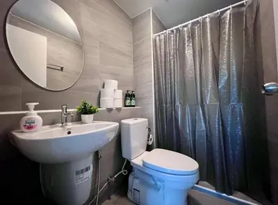 a bathroom with a sink and a toilet and a mirror at Minimal Condo At Ramkhamhaeng 64 in Sathani Ban Hua Mak