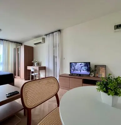 a living room with a table and a tv at Minimal Condo At Ramkhamhaeng 64 in Sathani Ban Hua Mak