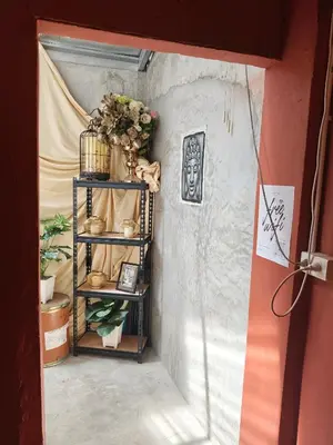 a room with a shelf with flowers and plants at Bangkhunnon Station Hostel in Sathani Thon Buri