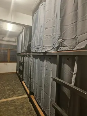 a row of gray curtains in a room at Bangkhunnon Station Hostel in Sathani Thon Buri