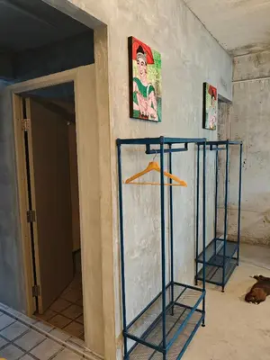a wall with scaffolding in a room with a dog at Bangkhunnon Station Hostel in Sathani Thon Buri
