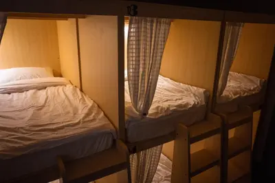 two bunk beds in a room with a window at Greet Hostel & Cafe Samyan in Bangkok