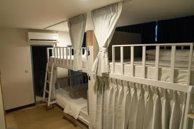 two bunk beds with white curtains in a room at Greet Hostel & Cafe Samyan in Bangkok