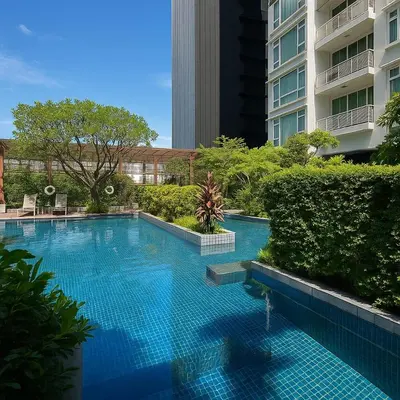 a large blue swimming pool in the middle of a building at Cozy High-Rise Escape in the heart of Bangkok! in Bangkok